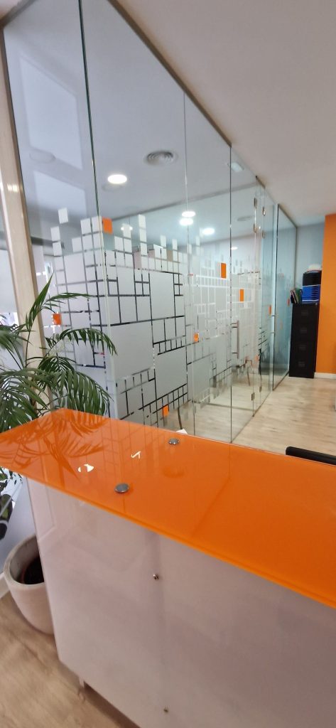 Recepción moderna con mostrador naranja en las oficinas de Prasser & Asociados, expertos en asesoría en Legazpi